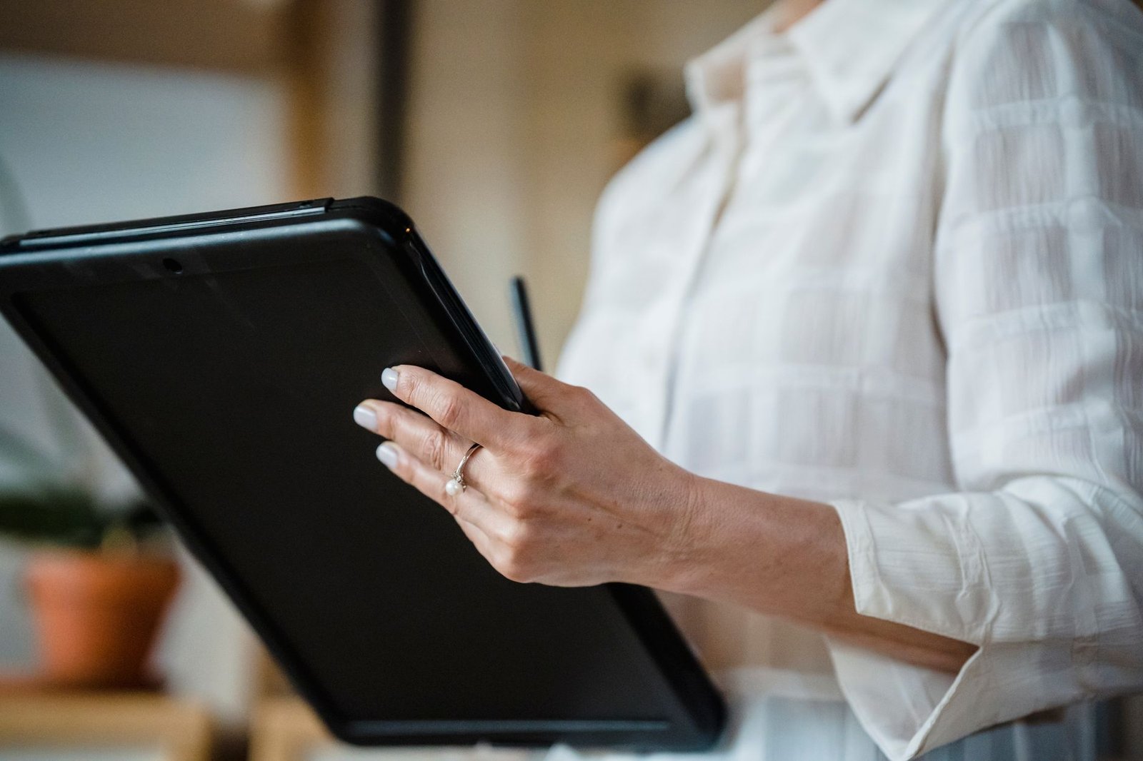 A person using a stylus to take notes on a budget Android tablet.
