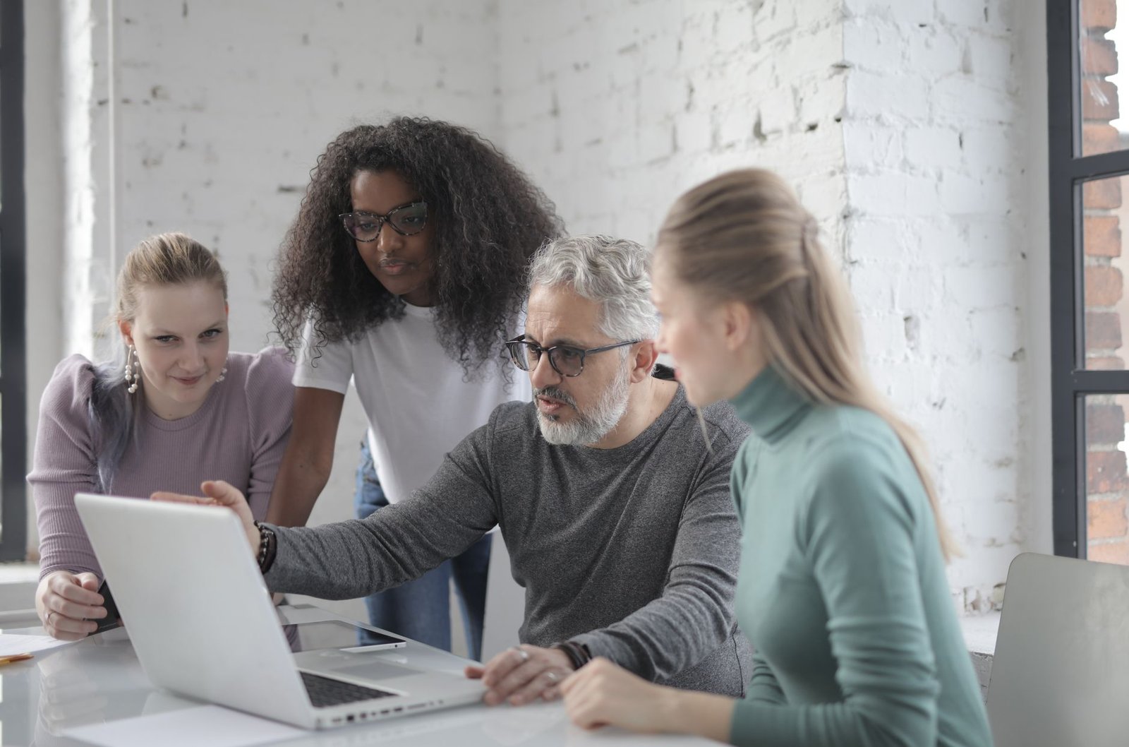 Diverse group of developers collaborating on a project using cloud IDEs on their screens.
