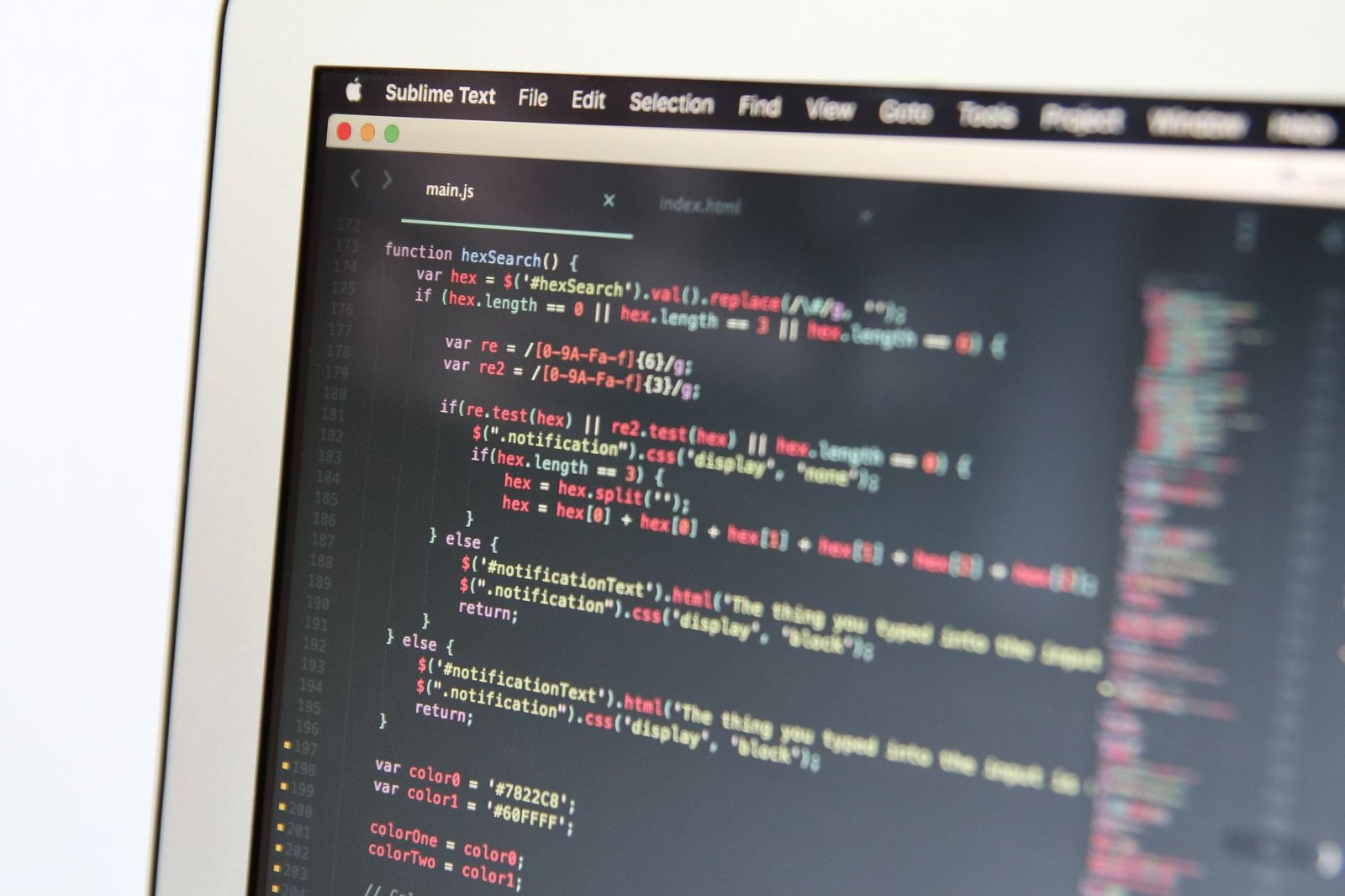 Close-up of a laptop screen showing a modern code editor with active syntax highlighting and auto-complete dropdown.