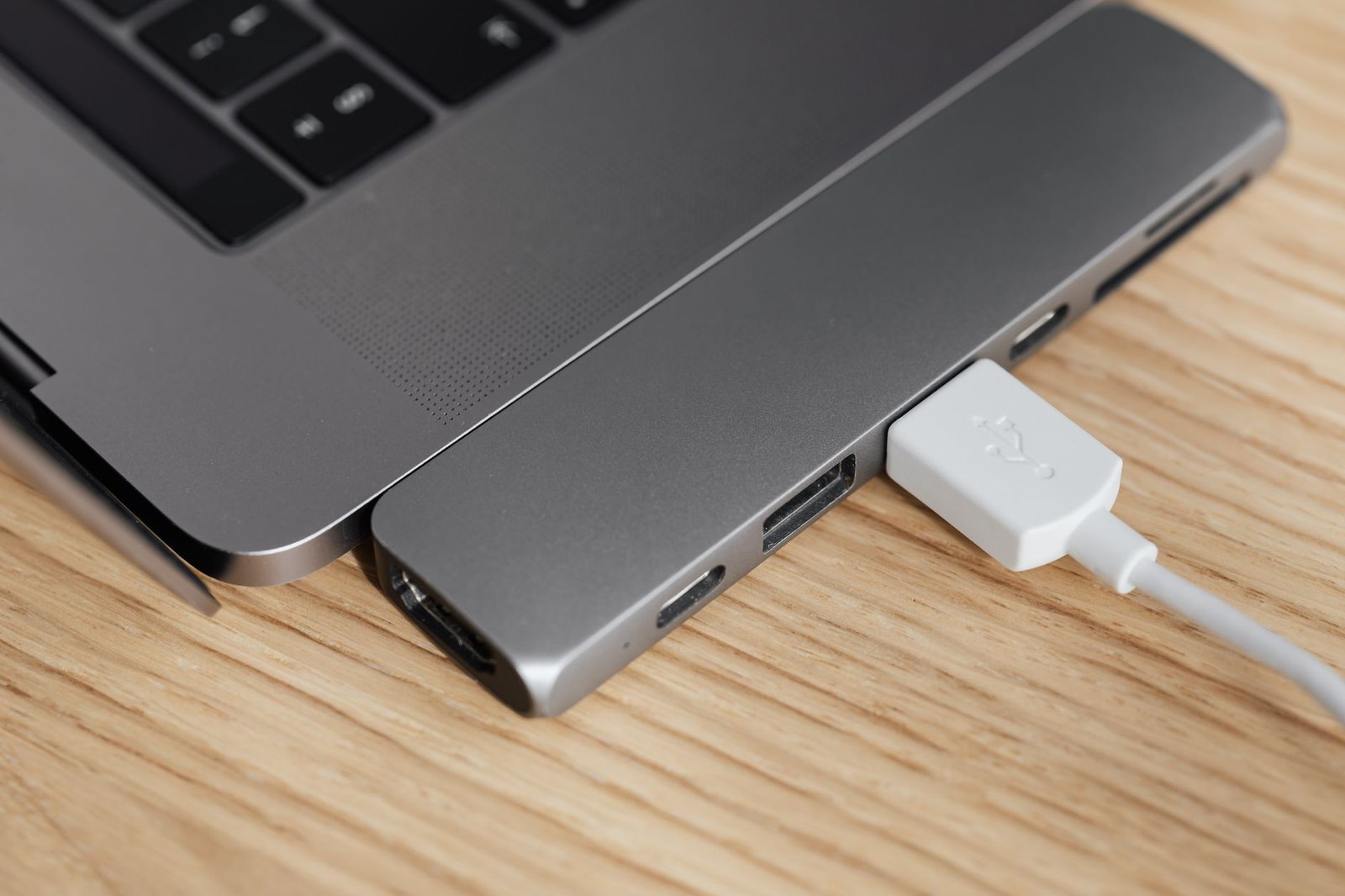 A modern MacBook Pro connected to various peripherals via a USB-C hub.