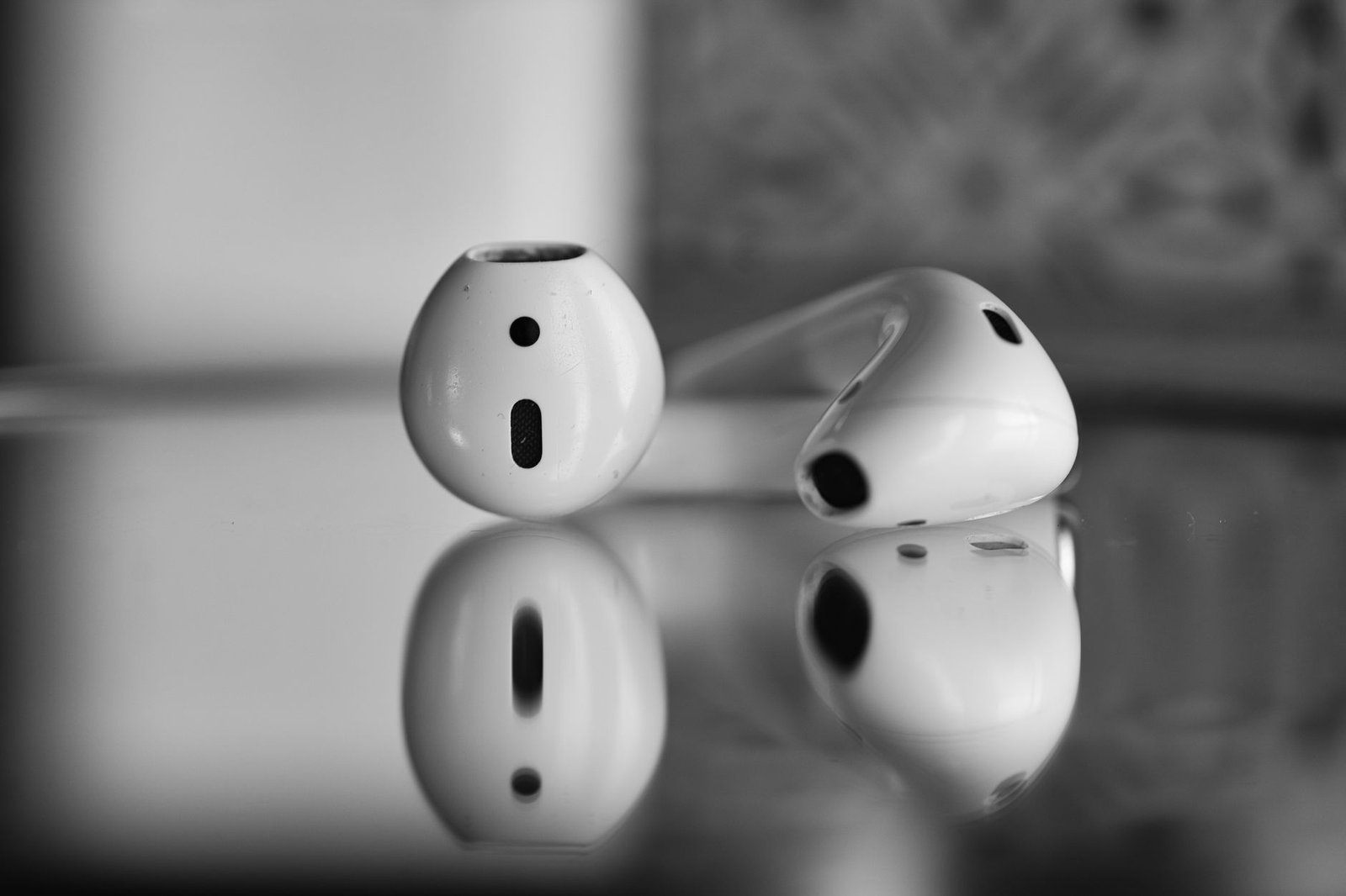 Wireless earbuds undergoing sound quality testing with audio analysis equipment.